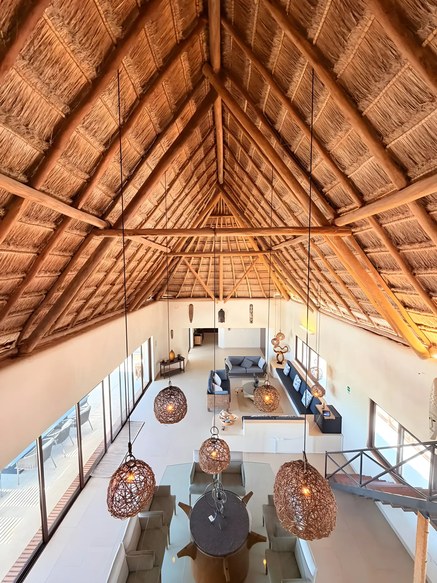 Interior de Casa María bajo la palapa de siete metros, con sala y comedor de doble altura
